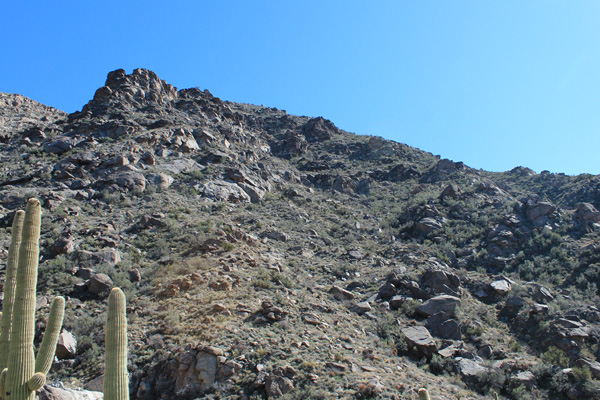 The trail traverses steep slopes ahead as it climbs to the saddle.