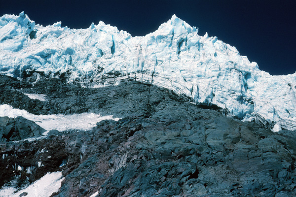 The Kautz Ice Cliffs tower above Camp Hazard at 10800 feet. The fall line takes falling ice off to the left or right from this camp.