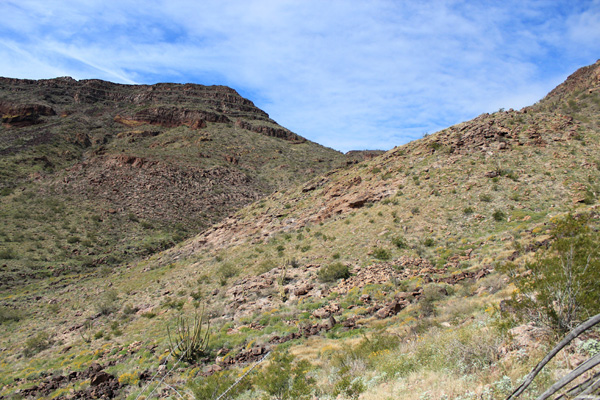 The mostly open traverse towards the upper saddle with the summit plateau above cliffs on the left