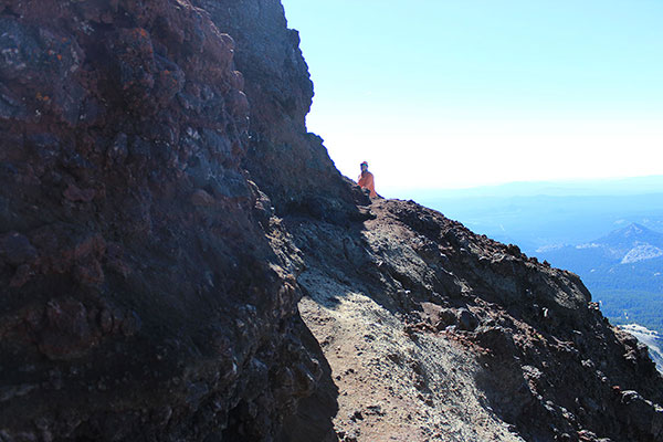 Above the basalt wall Bob follows a foot path south beside a cliff