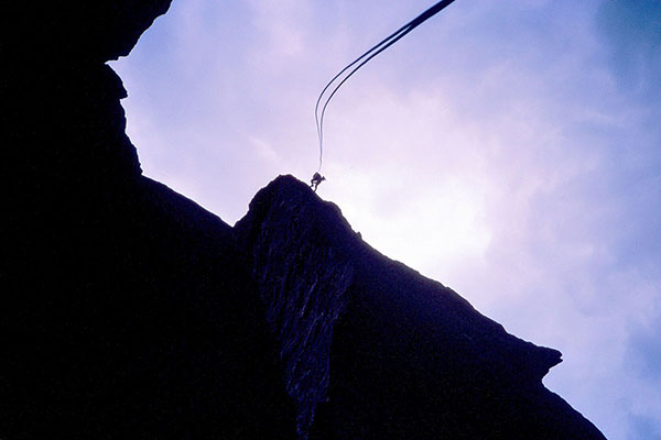 Linda starts her free rappel off Monkey Face above me. The breeze blows the rope about.