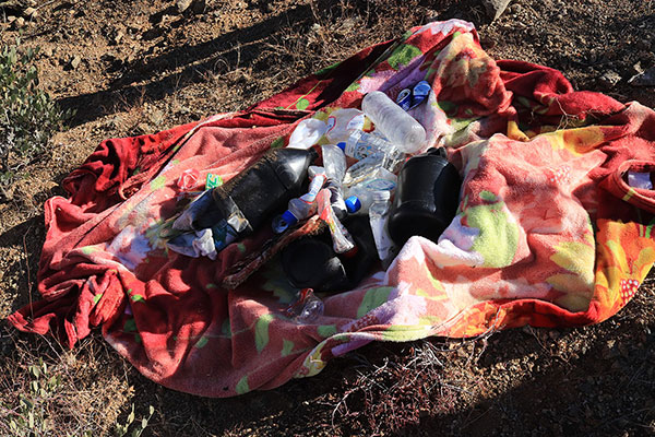 We collected trash at an abandoned camp. Scott carried it out to the cars.