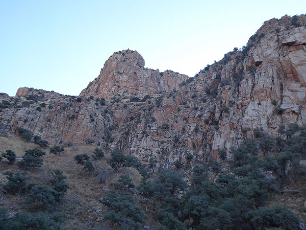 Valentine Peak rises above cliffs from high in Pima Canyon