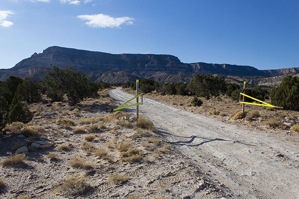 Black Mesa rises abruptly to the south beyond the open gate where I parked