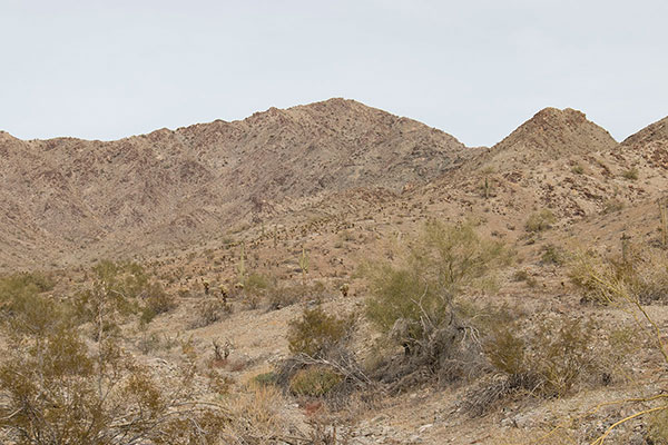 I follow the road to just below the subsidiary peak on the right, then traverse below it to gain the saddle beyond it.