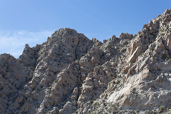 Our route leads up the steep gully right of center to just below a notch, then traverses left on a ledge across the high face