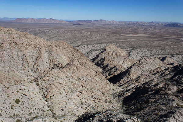 Our summit view down towards our ascent gully far below; the Cabeza Prieta Mountains lie across the desert